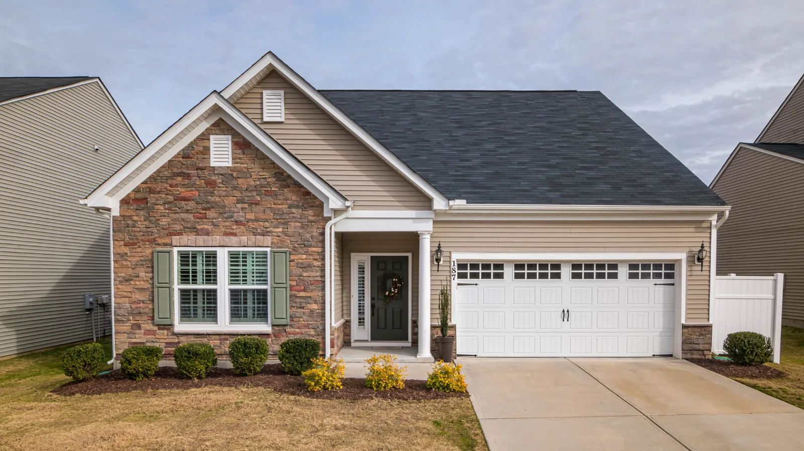 Stone and siding ranch home with a dark gray asphalt shingle roof